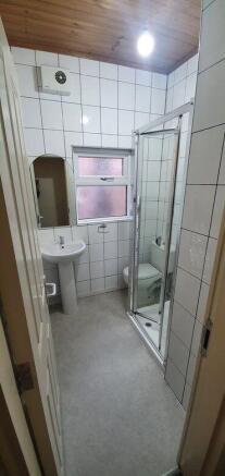 Bright tiled bathroom with a corner shower cubi...