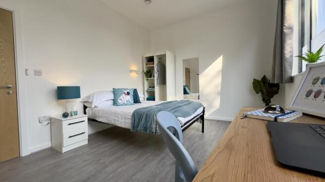 A spacious and bright double bedroom featuring ...