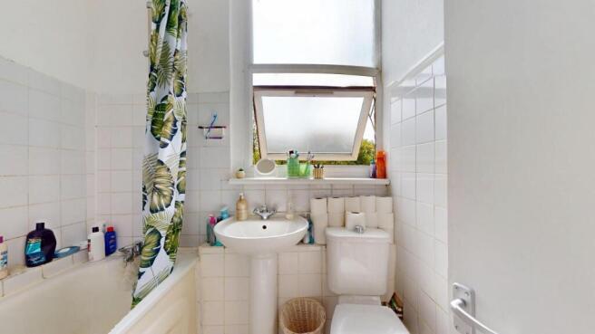 Bright bathroom with large window and bath...
