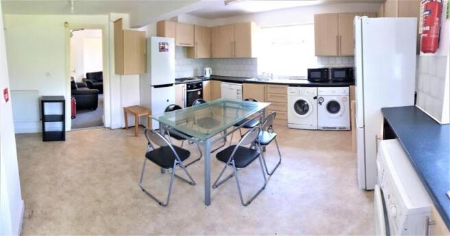 Bright open-plan kitchen with light wood cabine...