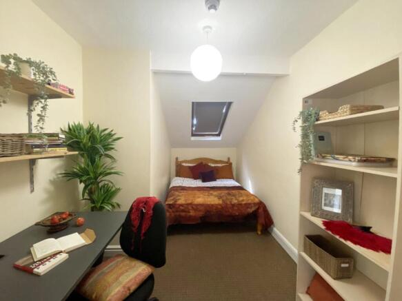 Bright, neatly arranged bedroom with a double b...