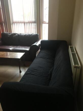 Bright living room with large windows, two comf...