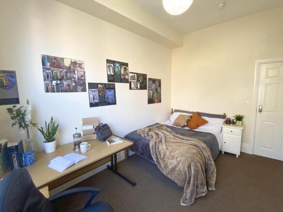 Bright, neatly arranged bedroom with a comforta...