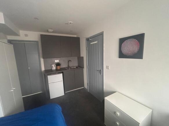 Compact room with kitchenette and storage...