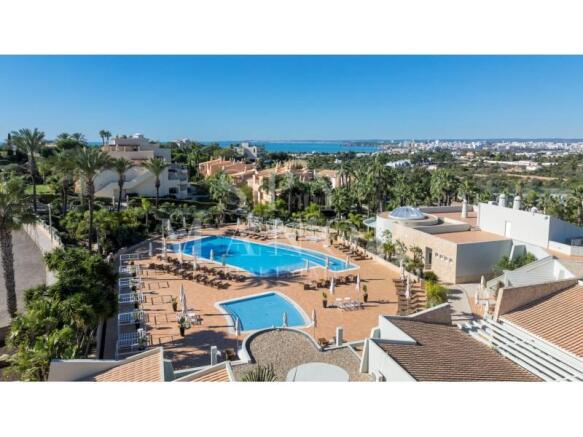 Aerial view of resort townhouse with swimming pool and sea views in Ferragudo, Algarve.