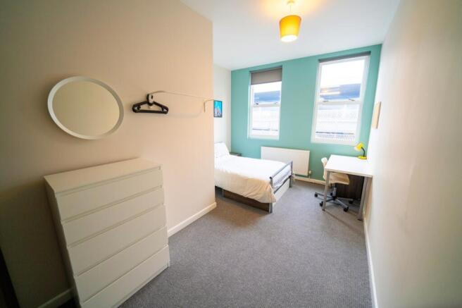 Bright and welcoming bedroom featuring two larg...