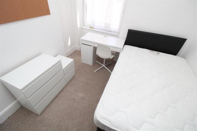 Bright modern bedroom with desk and ample stora...