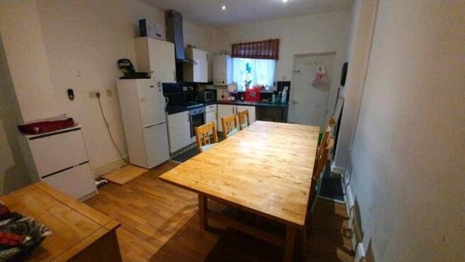 Bright communal kitchen with a large wooden din...