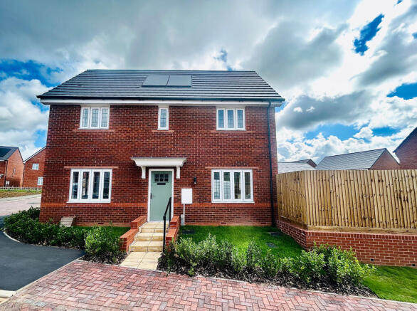 A modern red brick house with a light blue door stands in the foreground