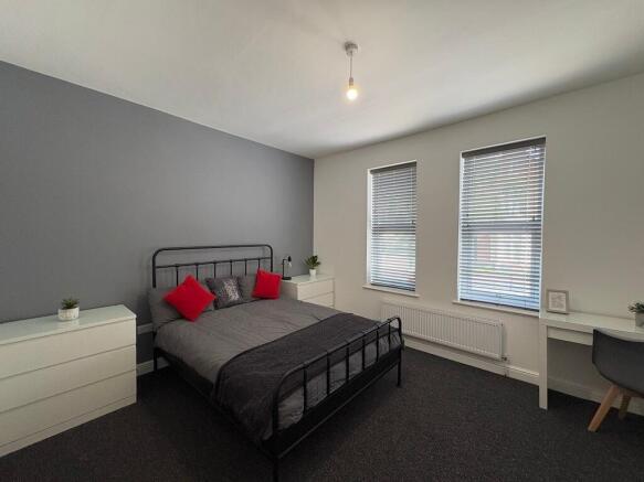 Bright, modern double bedroom with a metal-fram...