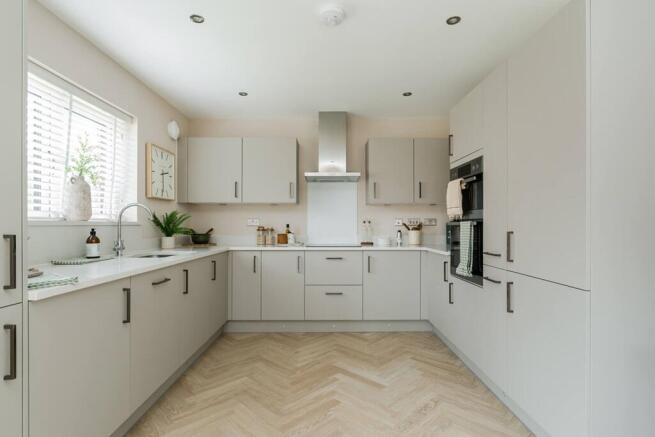 Modern fitted kitchen featuring generous worktop space and integrated appliances
