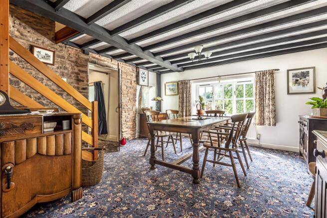 Dining room with ceiling beams & views of garden