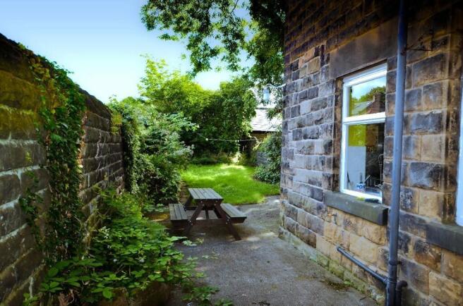 A peaceful garden area featuring a wooden picni...