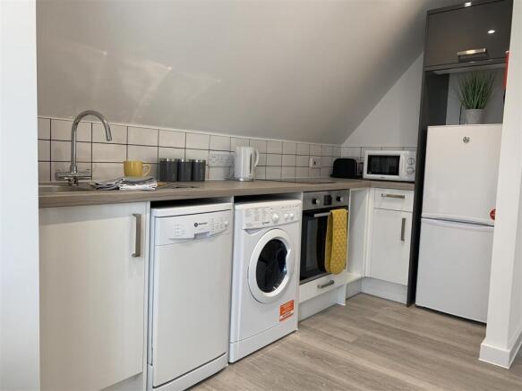 Modern kitchen with built-in laundry appliances...