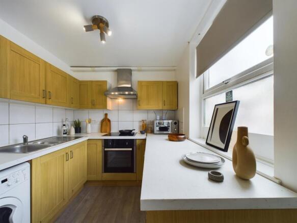 Bright, modern kitchen with wooden cabinets, in...