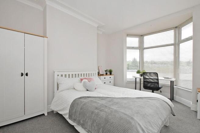 Bright, neatly styled double bedroom with a com...