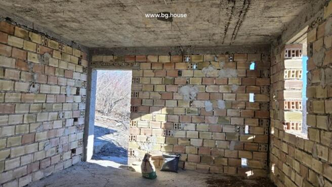 Inside view of an unfinished brick room with an open doorway leading outside.