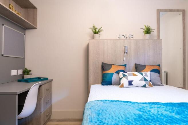 Bright, neatly styled single bedroom with a com...