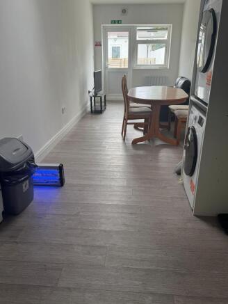 Modern living space with dining area and laundr...