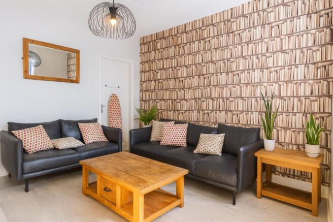 Bright, stylish living room with two black leat...