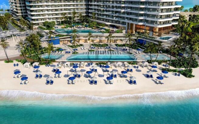 A beachfront resort with blue umbrellas and lounge