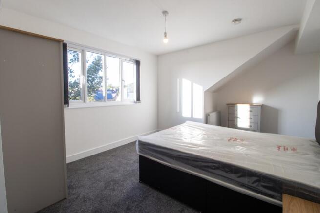Bright and airy bedroom featuring a large windo...