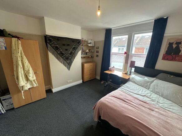 Spacious bedroom with ample storage and desk ar...