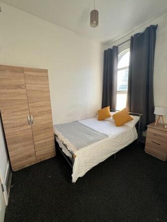 Cozy double bedroom featuring a comfortable bed...