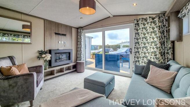Spacious lounge with patio doors and electric fire