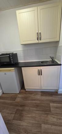Compact kitchenette with cabinets and sink...
