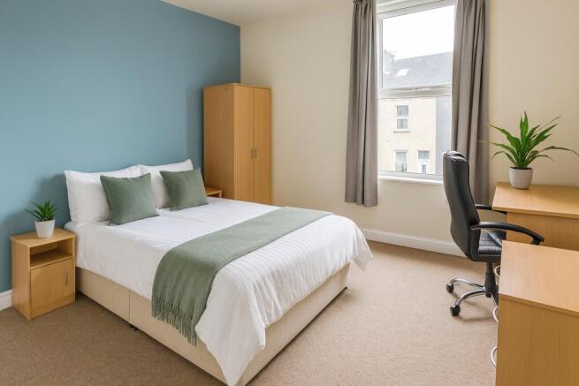 Bright bedroom with desk, wardrobe and modern b...