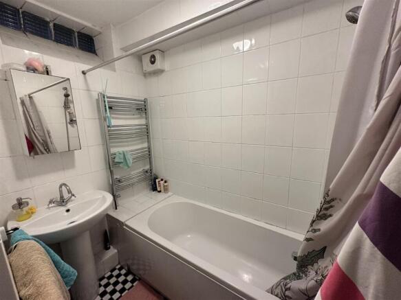 Clean bathroom with tub and heated towel rail...
