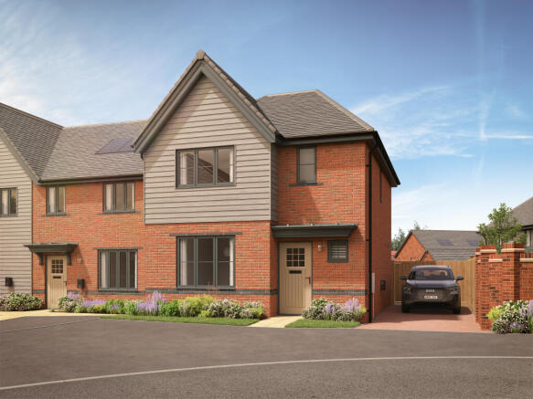A modern brick and wood townhouse with a driveway and car sits in front of a clear blue sky with wis