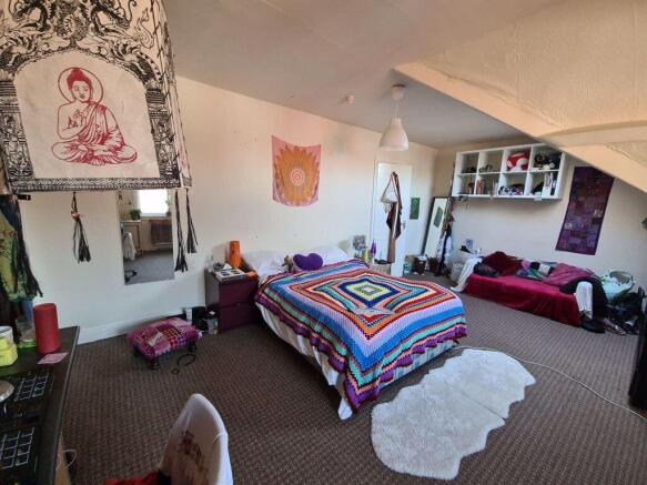A bright and cheerful bedroom featuring a large...