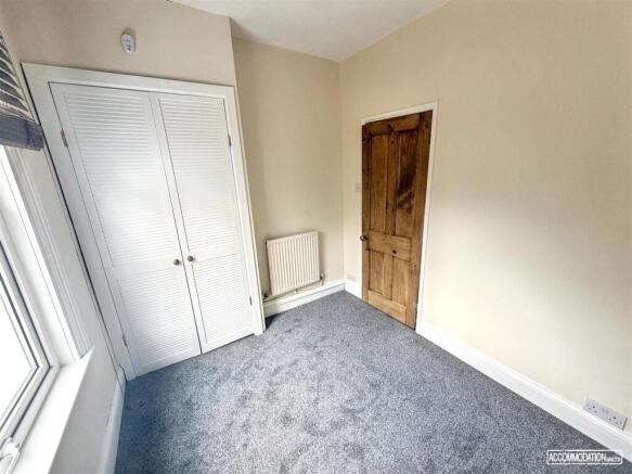 Bright bedroom with plush carpet and wardrobe...