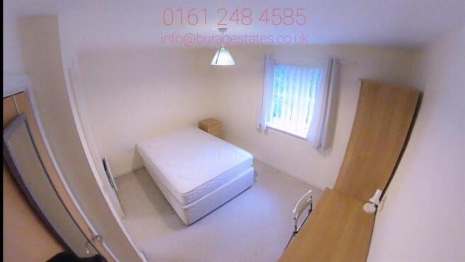 Bright, simply furnished bedroom with a neatly ...