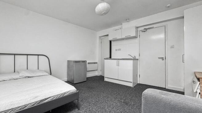Well-kept single bedroom with a simple metal do...