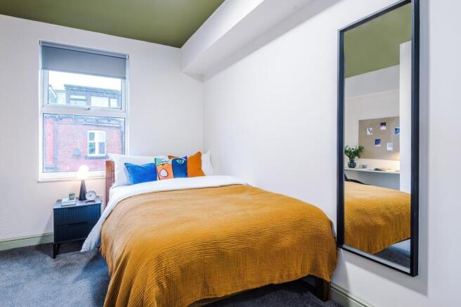 Modern bedroom with large mirror and natural li...