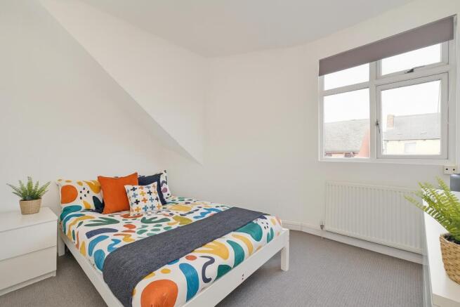 Bright and clean double bedroom featuring a col...