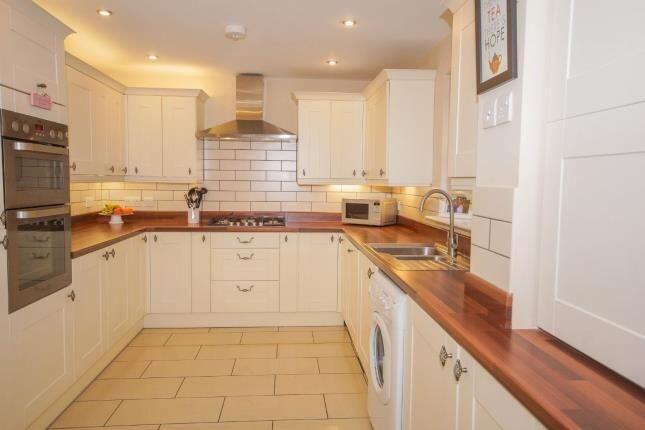 Bright, modern kitchen with cream cabinetry, wa...