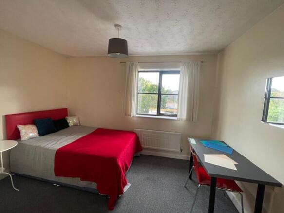 A spacious and bright double bedroom with a com...