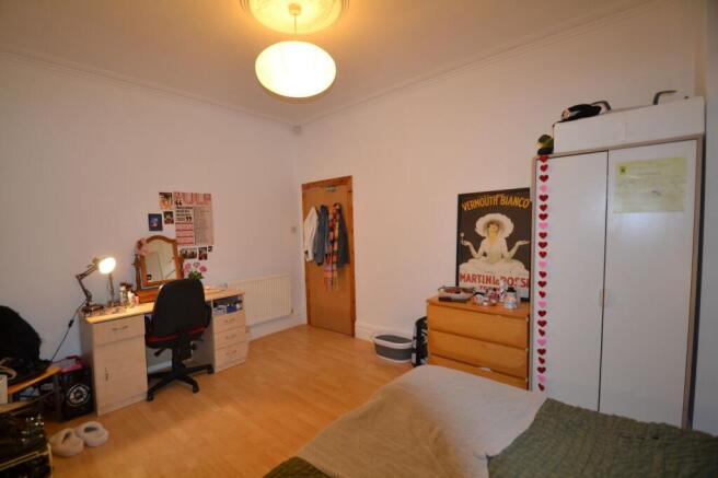 A bright and tidy bedroom featuring a comfortab...