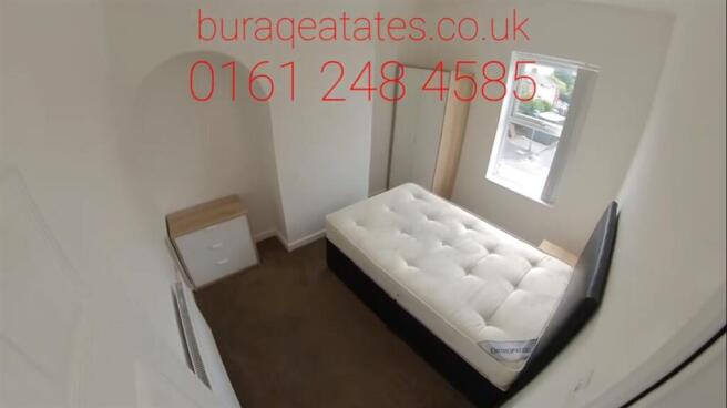 Bright, simply furnished bedroom with a comfort...