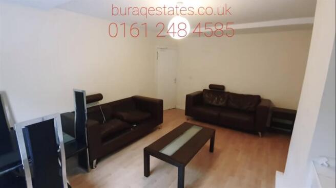 Bright, simply furnished living room with two b...