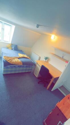 A cozy single bedroom with a large window provi...