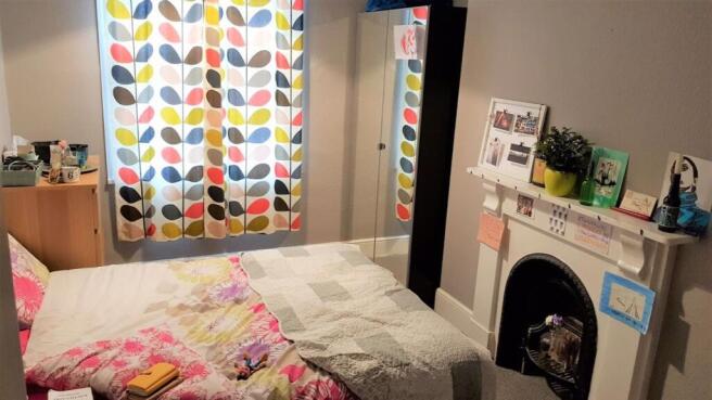 Bright and cozy master bedroom featuring a comf...