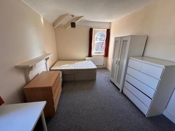 Bright, simply furnished bedroom with a single ...