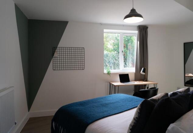 A stylish double bedroom featuring ample natura...