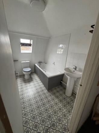 Bright upstairs bathroom with patterned tile fl...