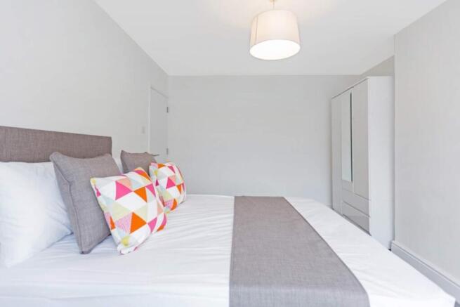 A spacious and bright double bedroom, featuring...
